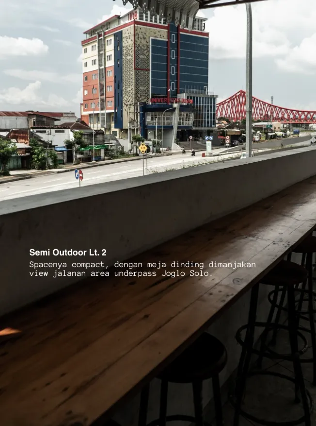 Meja dinding panjang di semi outdoor lantai dua ZA Coffee menghadap jalan, dengan pemandangan underpass Joglo Solo