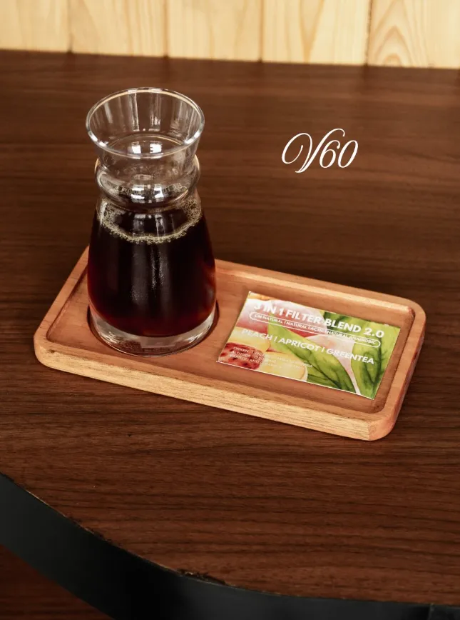 V60 dalam carafe kaca di atas nampan kayu, dengan sachet filter blend